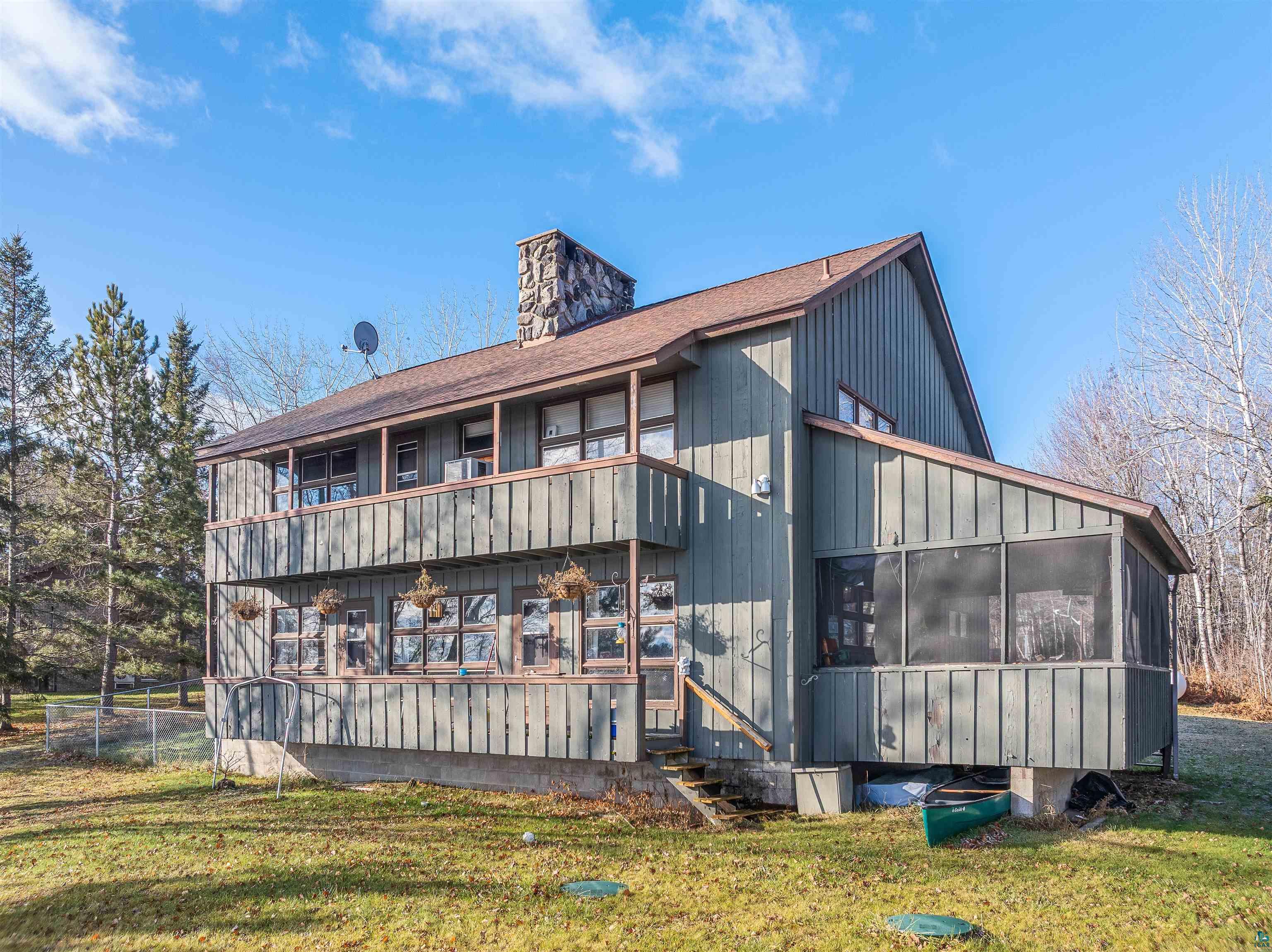 2641 Priest Point Road Ely, MN 55731 - Photo 33 of 38 Back of property featuring a yard, a sunroom, a chimney, and a shingled roof