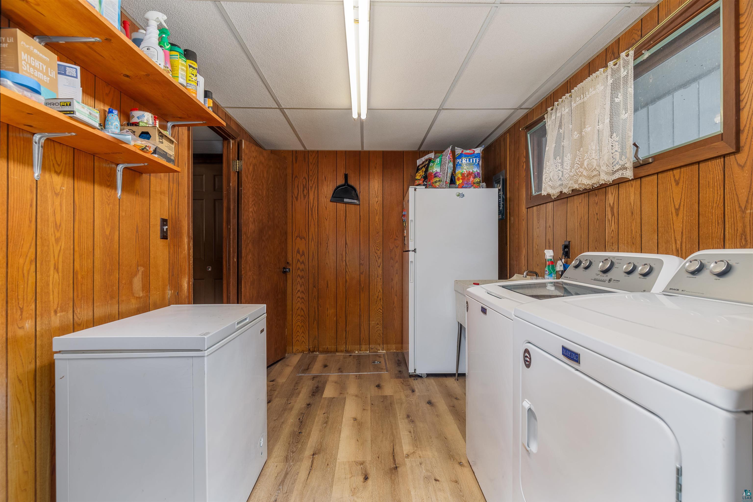 2641 Priest Point Road Ely, MN 55731 - Photo 36 of 38 Laundry room with wood walls, light wood-type flooring, a drop ceiling, and separate washer and dryer