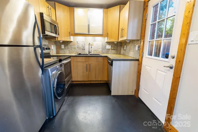 a kitchen with stainless steel appliances granite countertop a sink a stove and a microwave