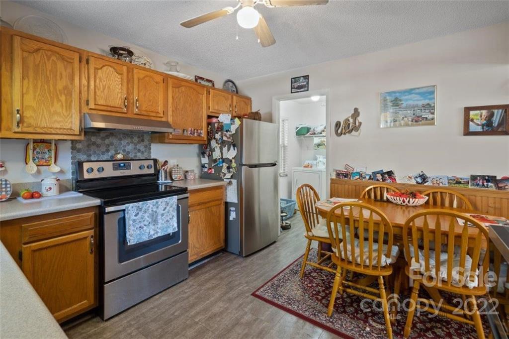 143 Mathis Dairy Road Spartanburg, SC 29307 - Photo 6 of 16 a kitchen with stainless steel appliances kitchen island granite countertop a refrigerator a stove a sink dishwasher and a microwave with wooden floor