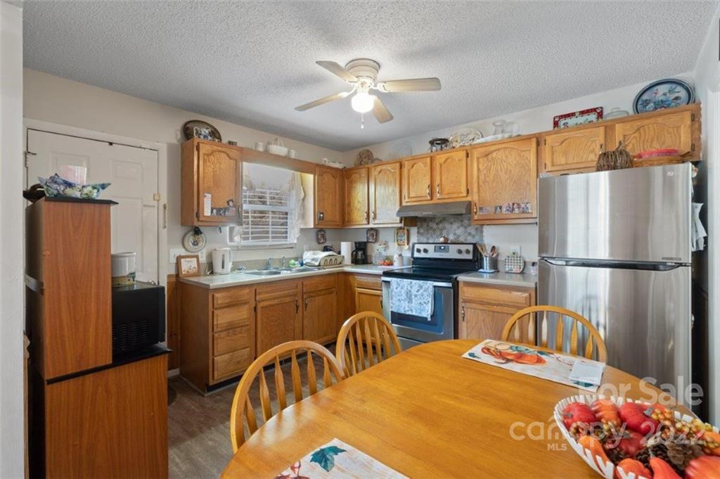 143 Mathis Dairy Road Spartanburg, SC 29307 - Photo 7 of 16 a kitchen with stainless steel appliances granite countertop a refrigerator a stove a sink dishwasher and a dining table with wooden floor