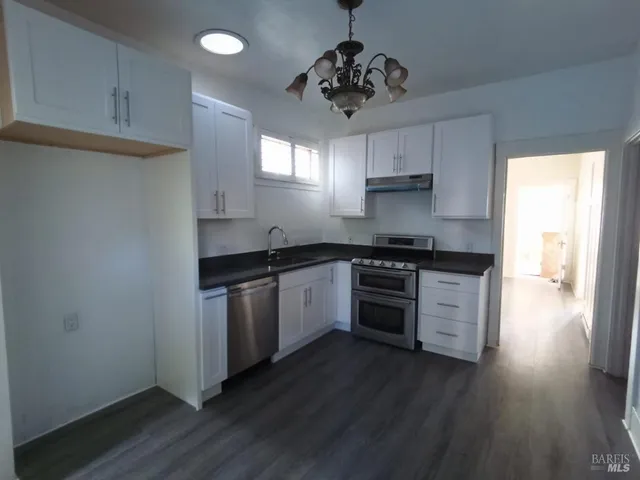 a kitchen with granite countertop a stove and a refrigerator