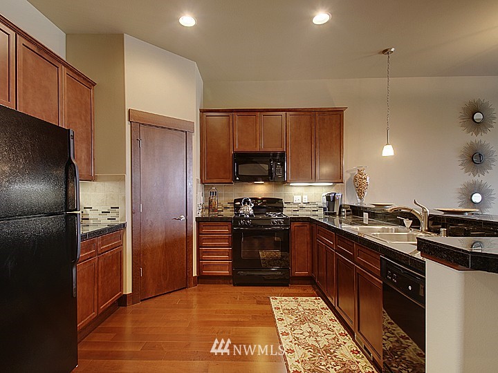 3910 Northeast 3rd Place Renton, WA 98056 - Photo 2 of 15 a kitchen with stainless steel appliances granite countertop a stove a refrigerator and a sink