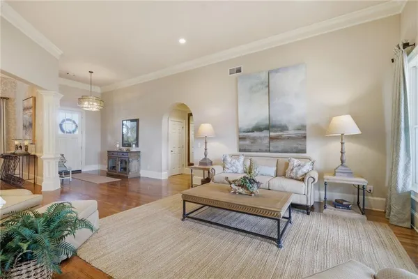 a view of a dining room with furniture a chandelier and wooden floor