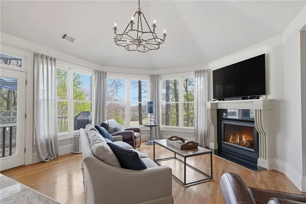 a kitchen with stainless steel appliances kitchen island granite countertop a table chairs and a wooden floor