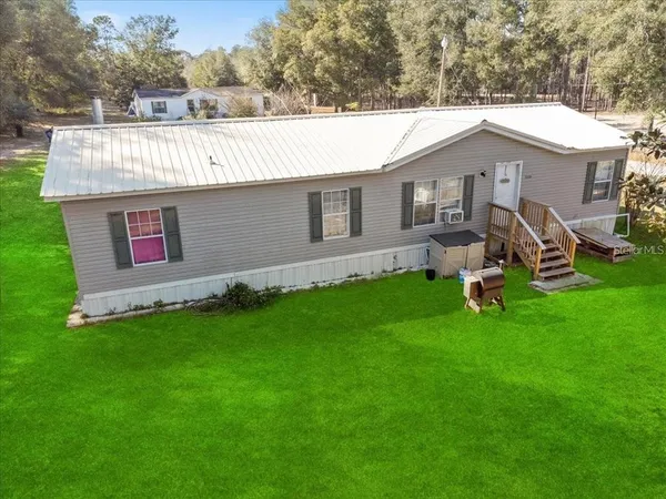 a view of a house with backyard and sitting area