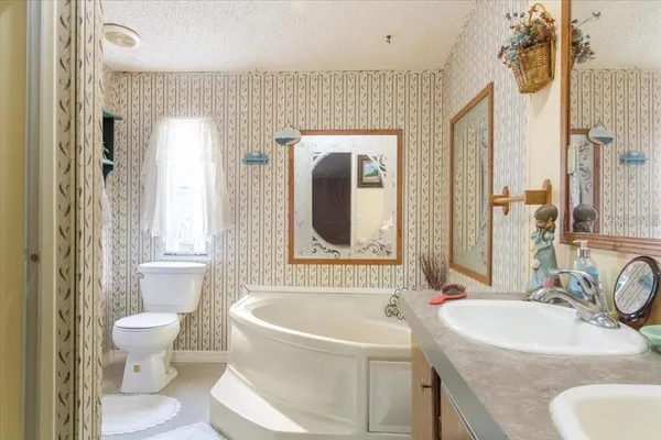 a bathroom with a granite countertop sink mirror vanity and toilet