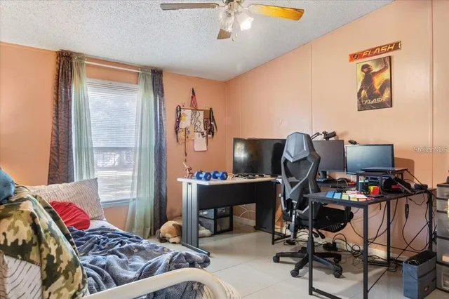 an empty room with wooden floor and fan