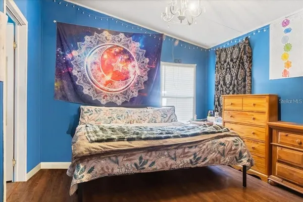 a bedroom with a bed and a chandelier