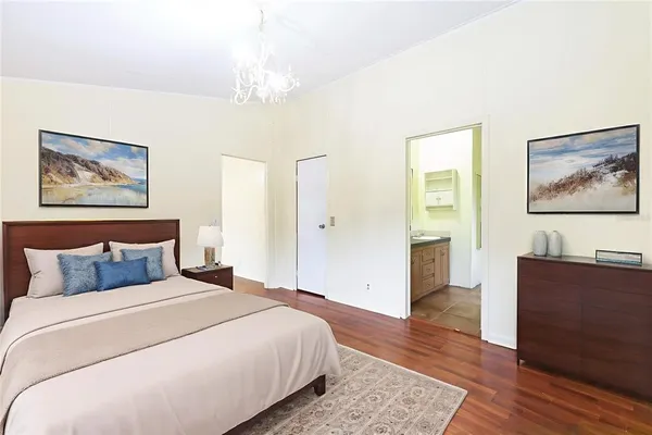an empty room with wooden floor and fan