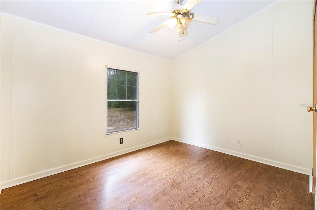 3230 Southwest 189th Avenue Dunnellon, FL 34432 - Photo 48 of 50 an empty room with wooden floor and fan