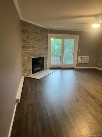 a view of a livingroom with wooden floor and a fireplace