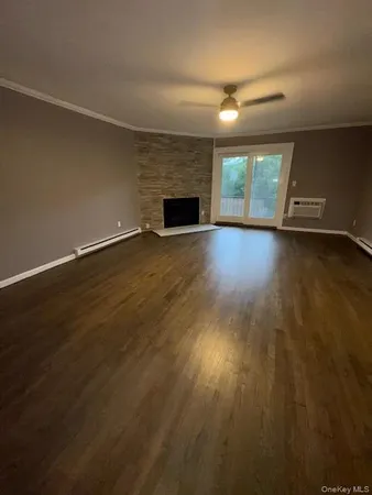 an empty room with wooden floor and fireplace