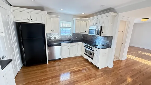 a kitchen with a refrigerator sink and cabinets