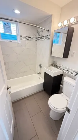 a bathroom with a toilet sink and mirror