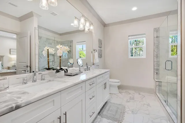 a spacious bathroom with a granite countertop sink a toilet and a mirror