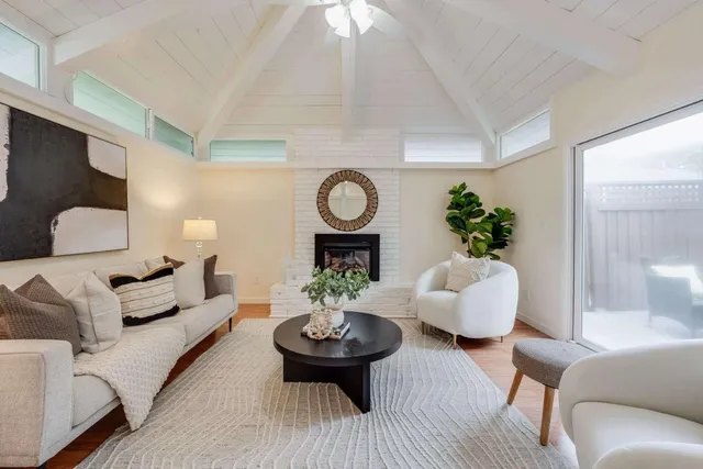 a living room with furniture a potted plant and a fireplace
