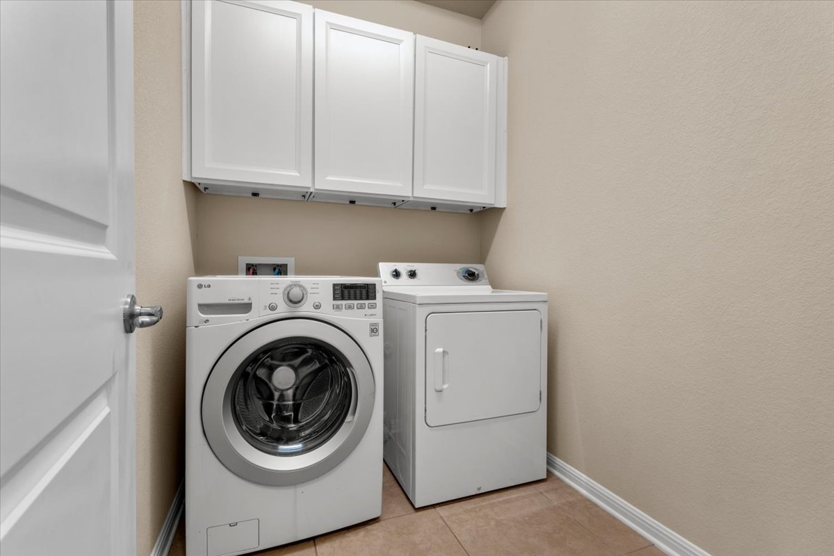 3451 Mayfield Ranch Boulevard, Unit 311 Round Rock, TX 78681 - Photo 18 of 40 Laundry room featuring tiled flooring, white cabinetry, and a light neutral wall color