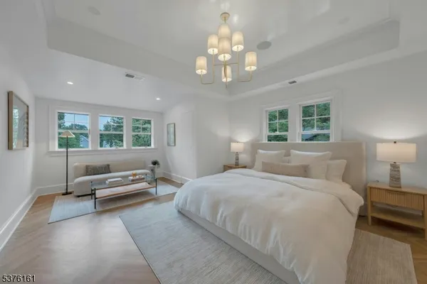 a bedroom with a large bed and a chandelier