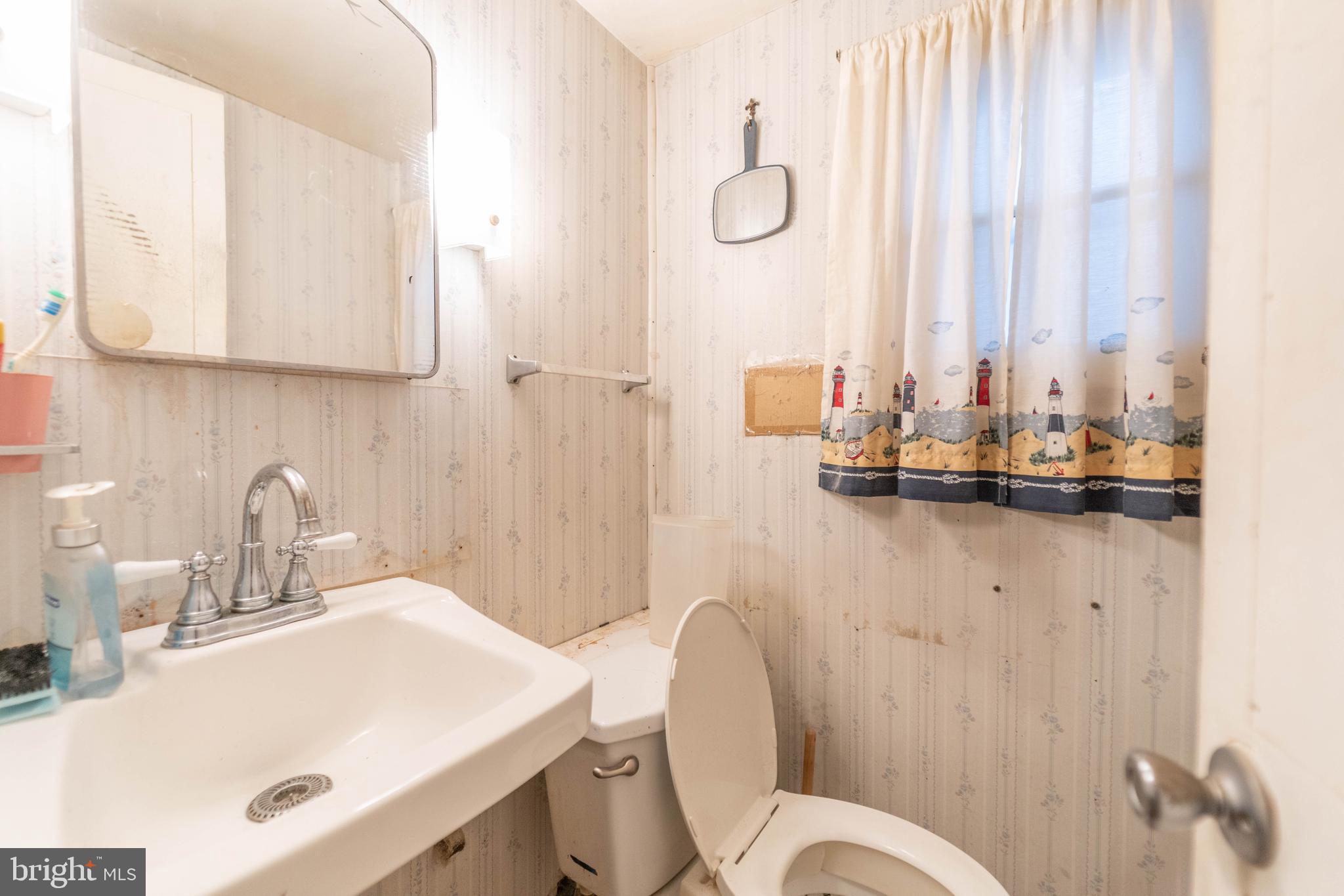 126 Olive Street Rancocas, NJ 08073 - Photo 7 of 12 a bathroom with a sink vanity mirror and toilet
