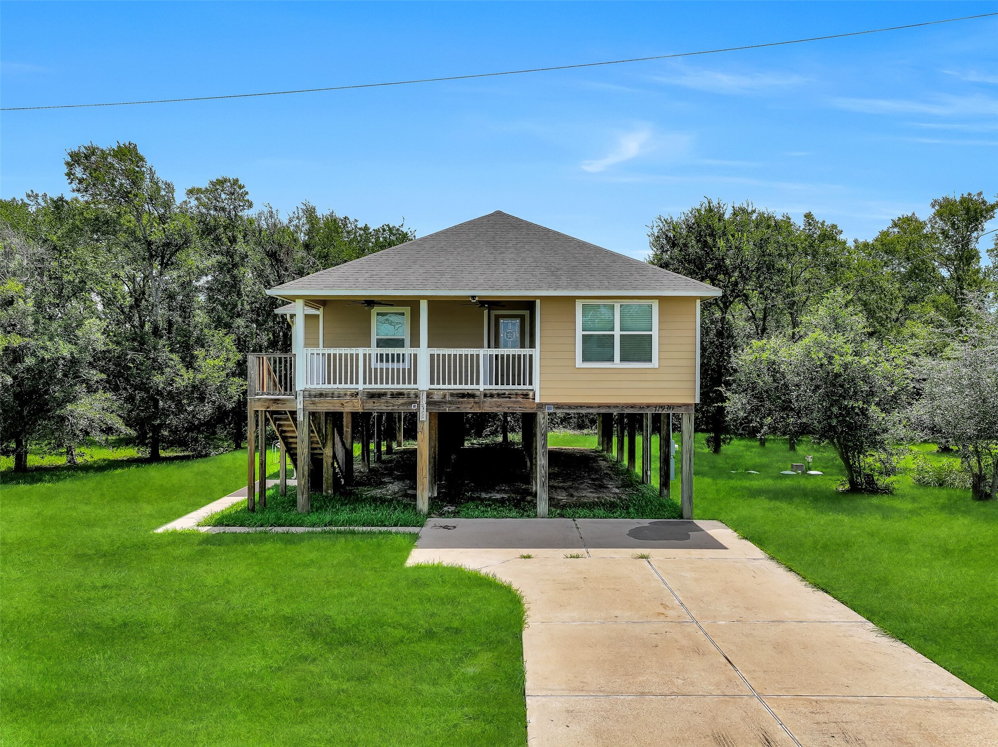 11930 Bastrop Beach Road Angleton, TX 77515 - Photo 7 of 29 The elevated design maximizes both function and outdoor living, with expansive green space surrounding the home and a covered front porch that invites you to slow down and enjoy the peaceful setting.