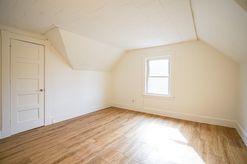 83-85 Wilmont Street, Unit 3 Springfield, MA 01108 - Photo 6 of 12 an empty room with wooden floor and windows
