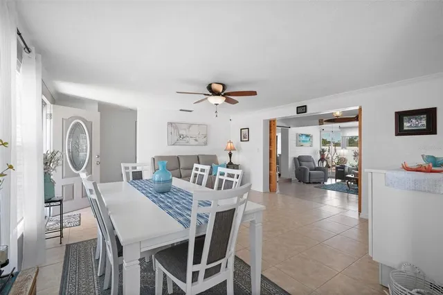 a kitchen with stainless steel appliances granite countertop a stove top oven a sink dishwasher a microwave oven and a dining table with wooden floor