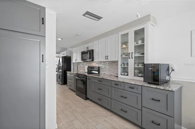 a kitchen with stainless steel appliances granite countertop lots of counter top space and wooden floor
