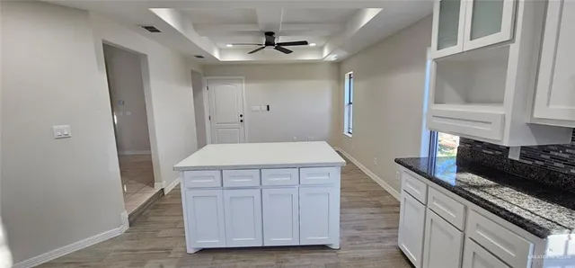 a kitchen with a wooden floor and a refrigerator
