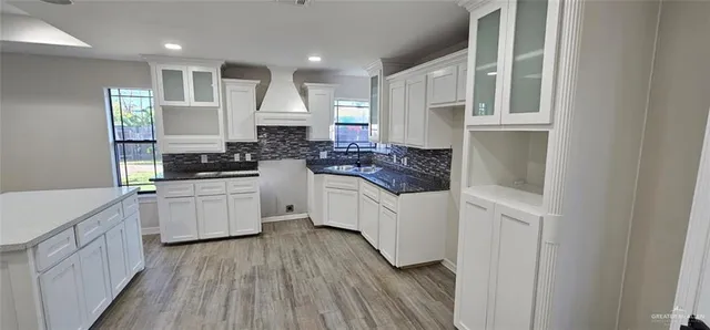 a kitchen with white cabinets and appliances