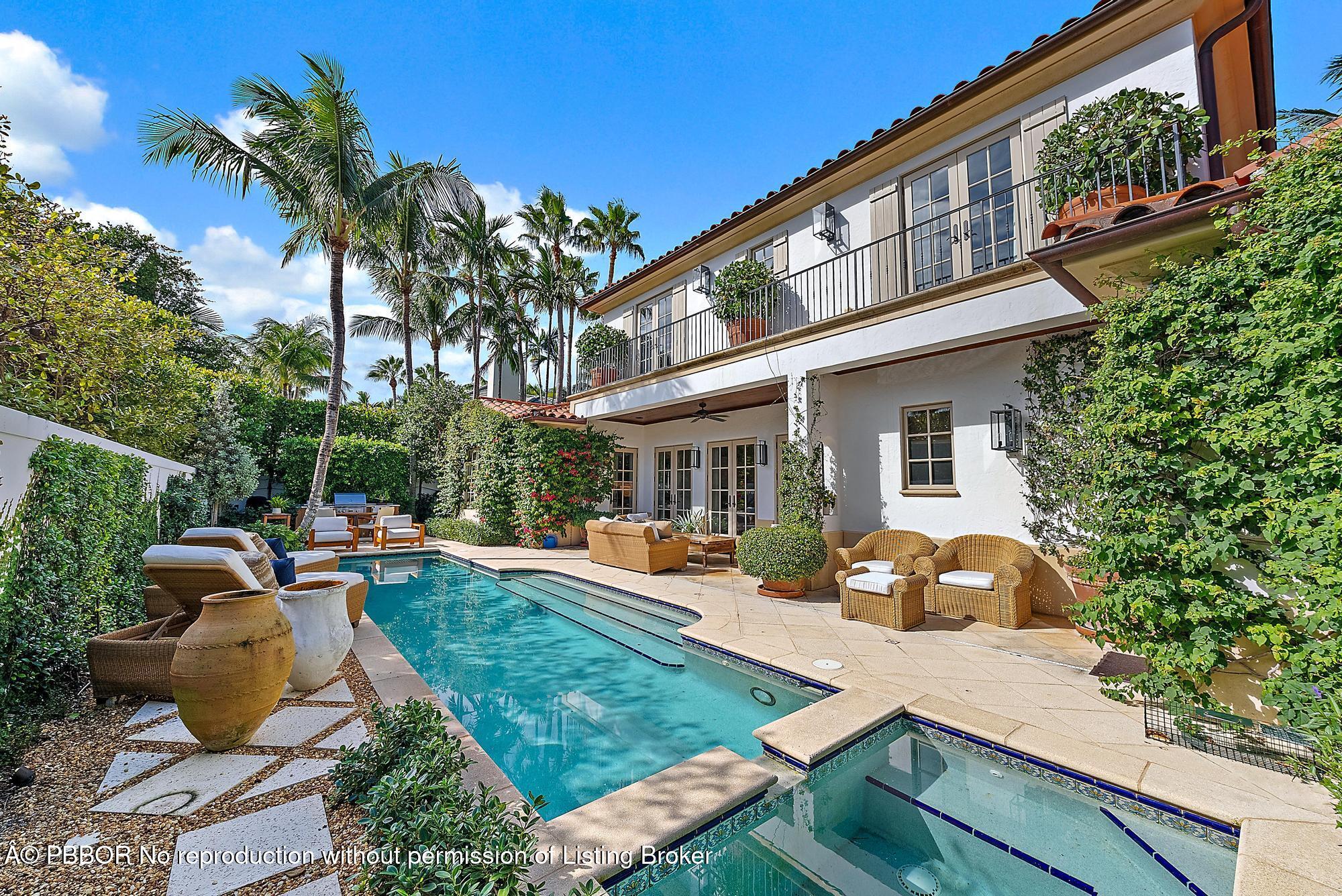 a front view of a house with garden and trees