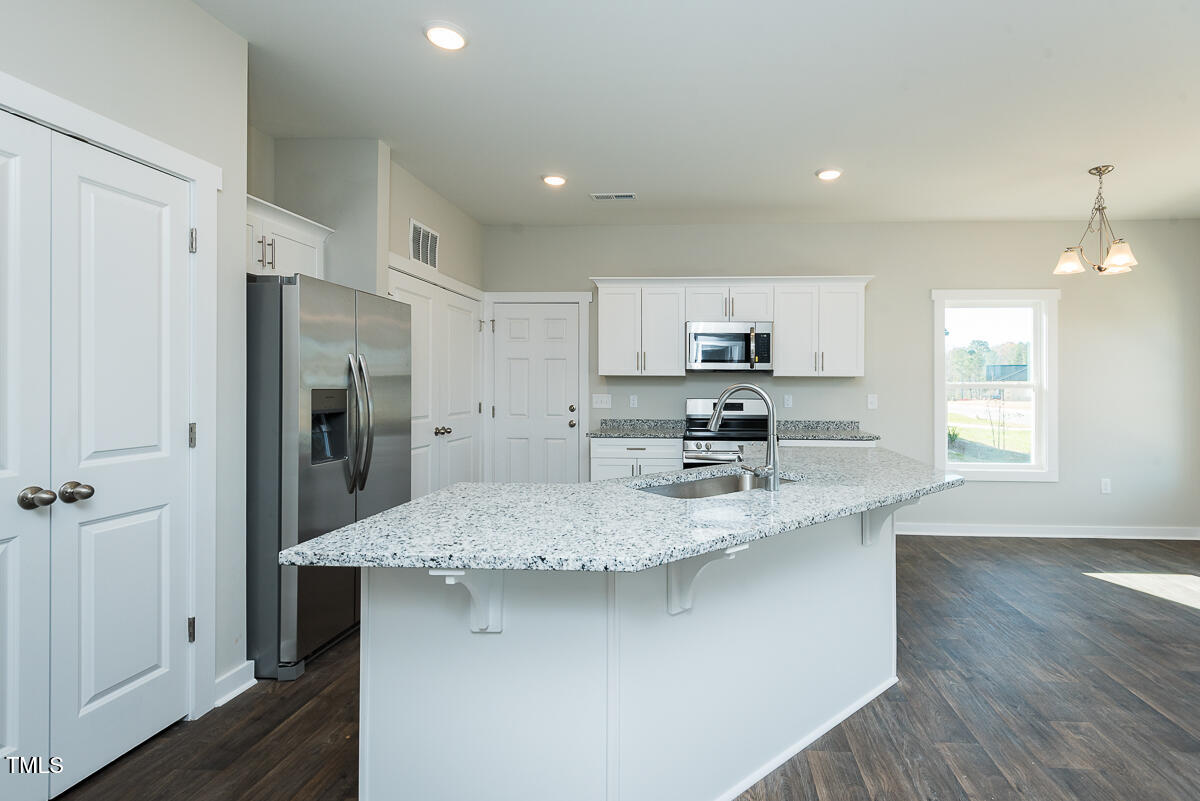 1030 Pinnix Loop Burlington, NC 27217 - Photo 11 of 25 a kitchen with stainless steel appliances granite countertop a sink refrigerator and cabinets