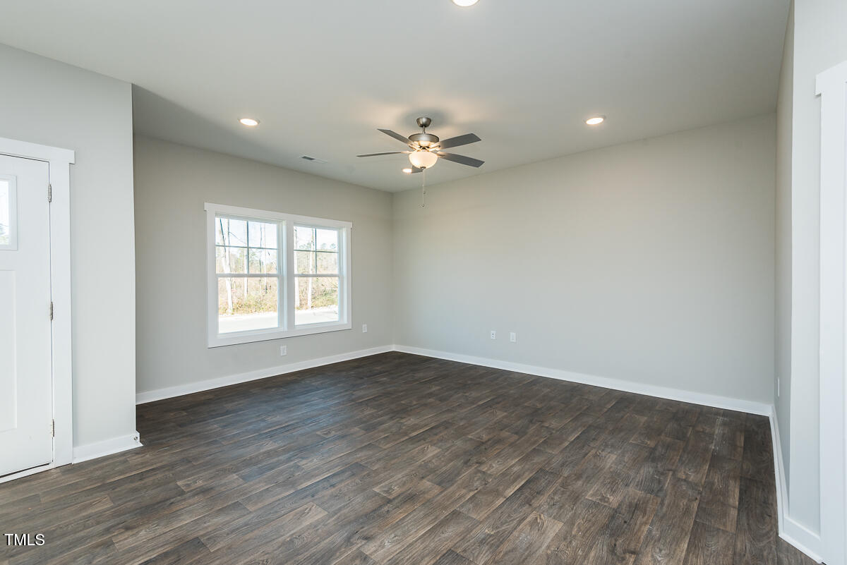1030 Pinnix Loop Burlington, NC 27217 - Photo 5 of 25 an empty room with wooden floor and a ceiling fan