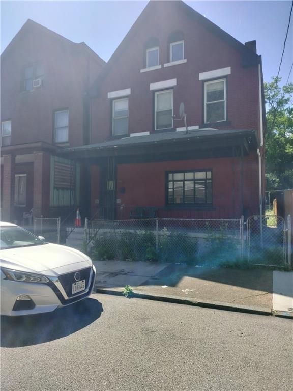 a car parked in front of a brick house