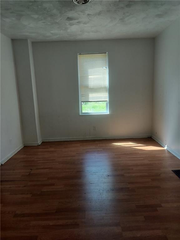 245 Fleet Street Braddock, PA 15104 - Photo 3 of 12 a view of an empty room with wooden floor and a window
