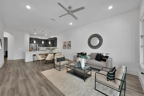 a living room with furniture and view of kitchen