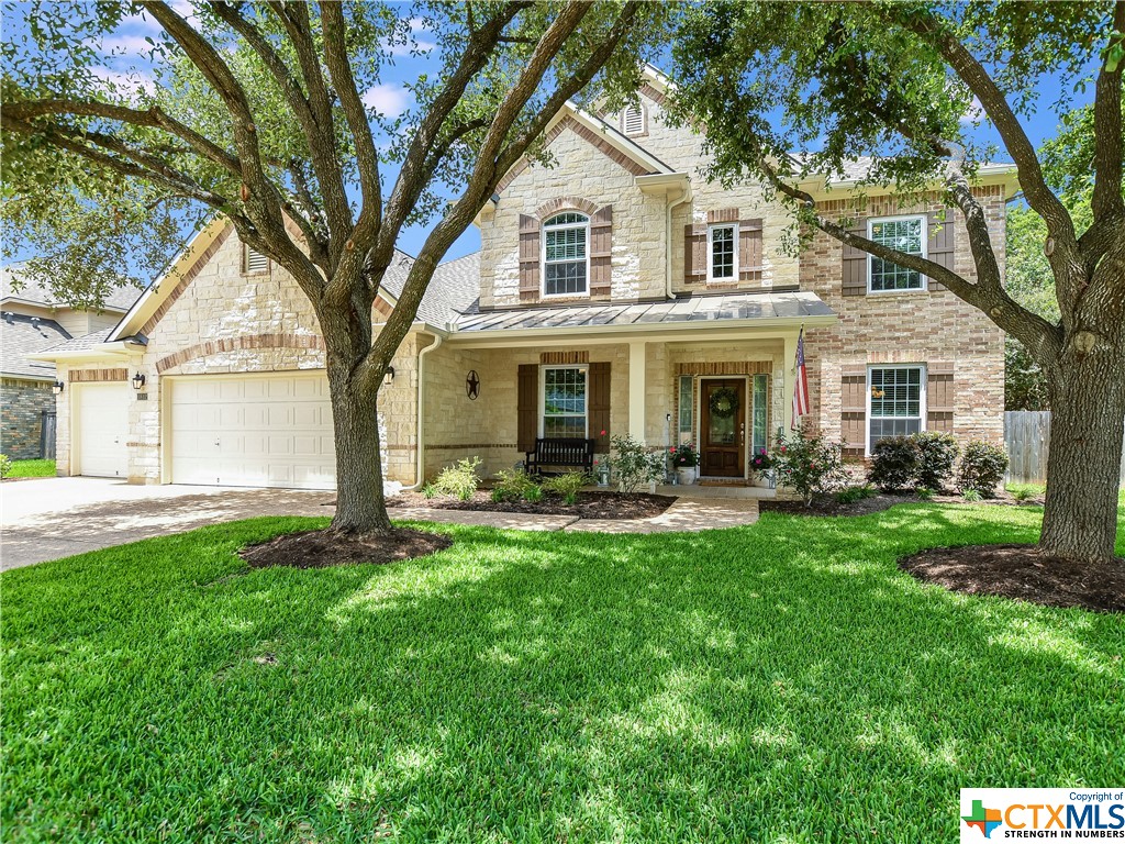 a front view of a house with yard patio and green space