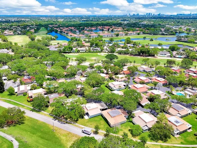 an aerial view of residential houses with outdoor space and trees