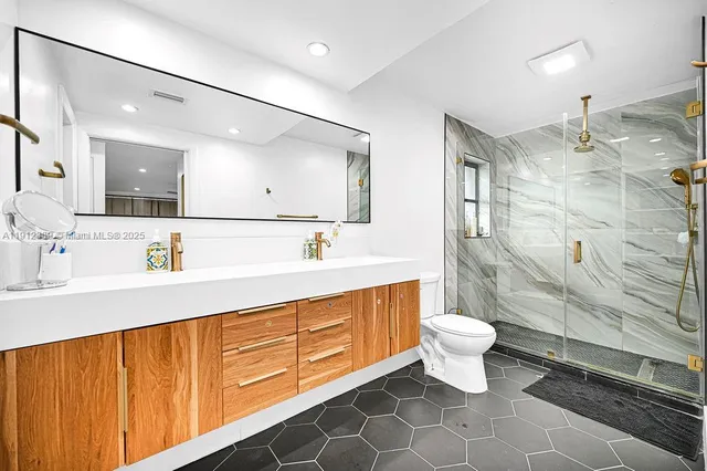a bathroom with a double vanity sink mirror and toilet