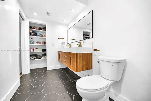 a bathroom with a toilet a sink and a mirror