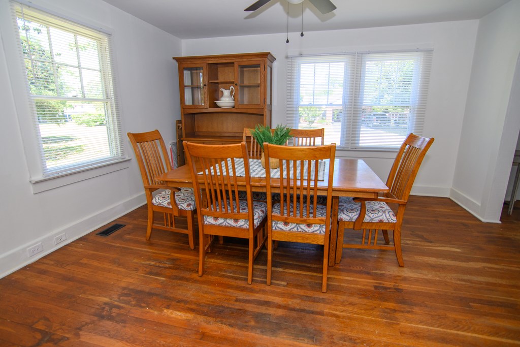 24432 Maxwell Street Parksley, VA 23421 - Photo 11 of 39 a dining room with furniture a chandelier and wooden floor