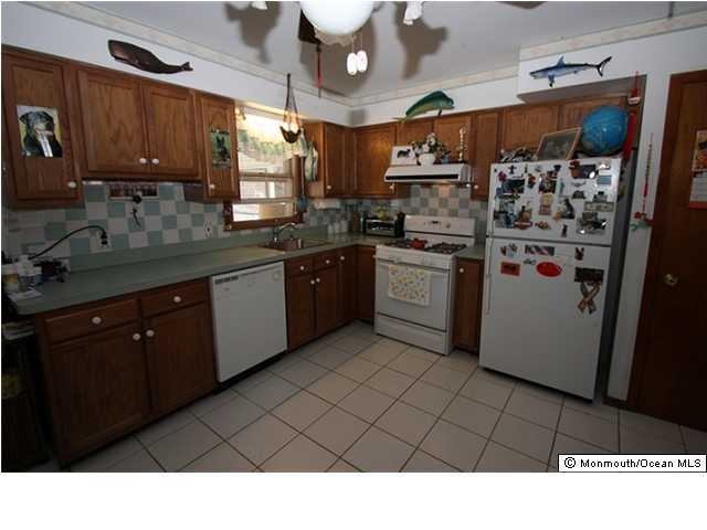 822 Beaver Dam Road Point Pleasant, NJ 08742 - Photo 3 of 3 a kitchen with stainless steel appliances granite countertop a refrigerator a sink dishwasher a dining table and chairs