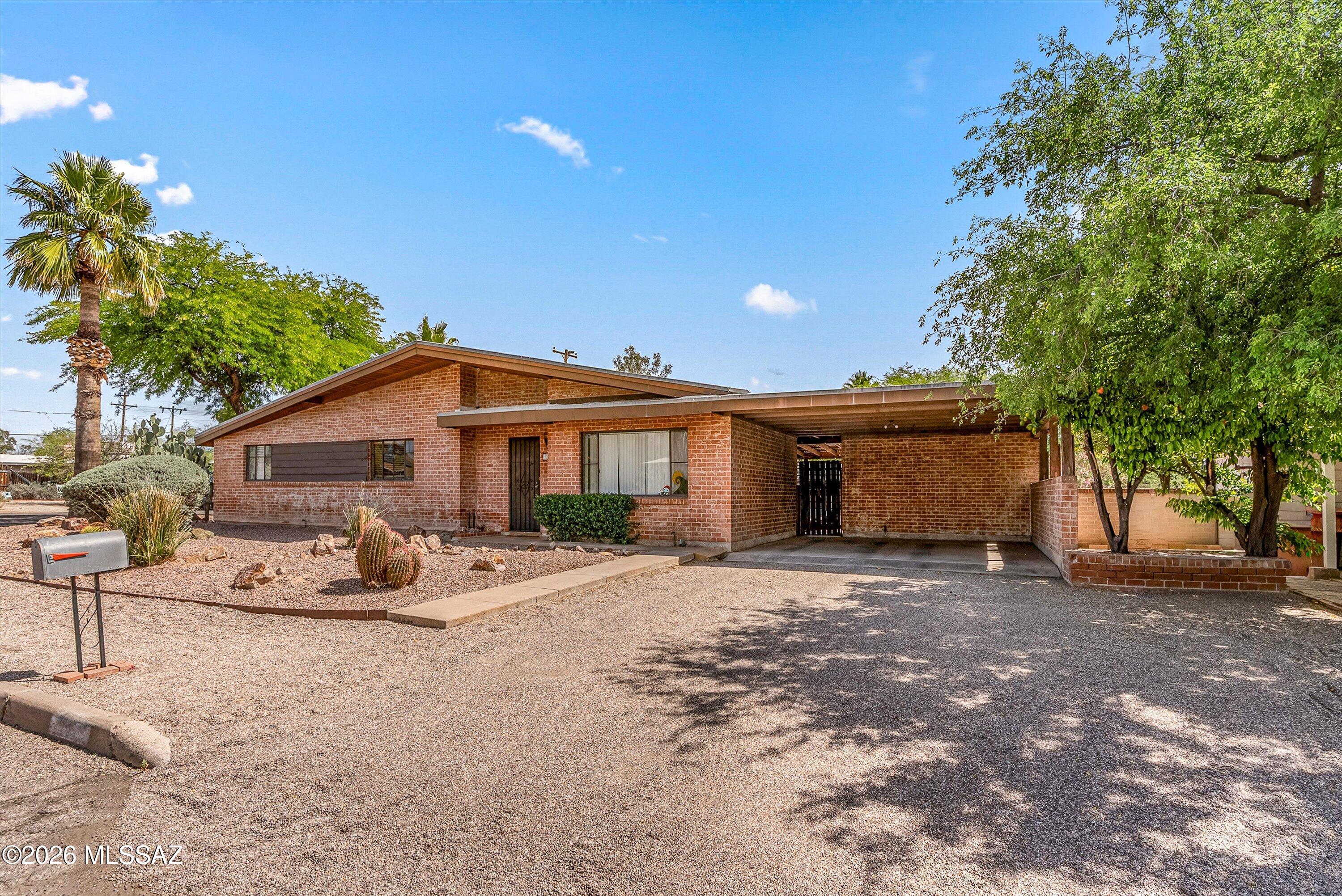 2934 East Exeter Street Tucson, AZ 85716 - Photo 3 of 20 a front view of house with yard outdoor seating and trees in the background