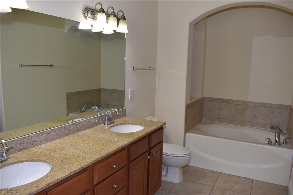 1311 Corso Palermo Court, Unit 2 Naples, FL 34105 - Photo 7 of 15 a bathroom with a granite countertop sink and a mirror