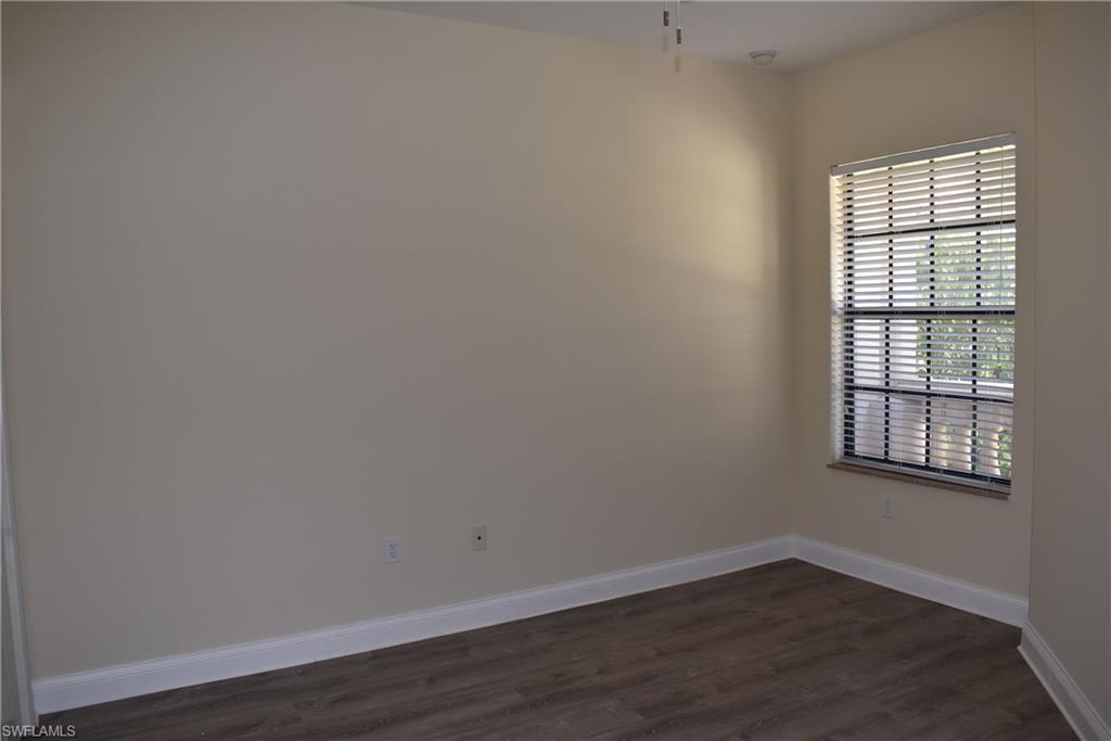 1311 Corso Palermo Court, Unit 2 Naples, FL 34105 - Photo 10 of 15 an empty room with wooden floor and windows