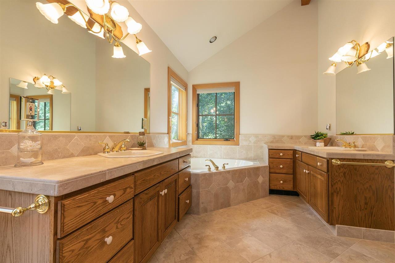 1722 Grouse Ridge Road Truckee, CA 96161 - Photo 15 of 21 a bathroom with a granite countertop double vanity sink a large mirror and a bathtub