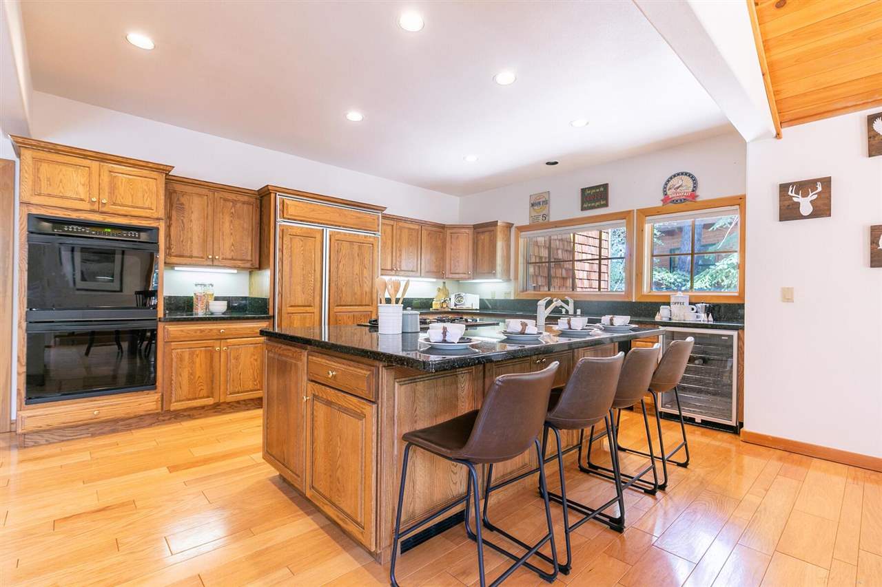 1722 Grouse Ridge Road Truckee, CA 96161 - Photo 6 of 21 a kitchen with stainless steel appliances granite countertop a stove top oven a sink dishwasher a dining table and chairs with wooden floor