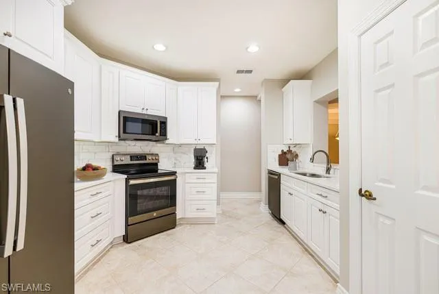 a kitchen with stainless steel appliances a stove sink and refrigerator