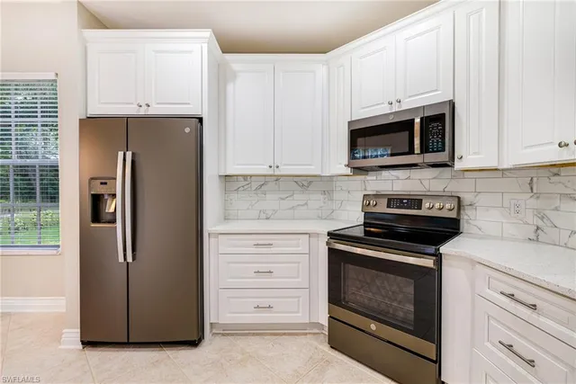 a kitchen with stainless steel appliances white cabinets and a refrigerator