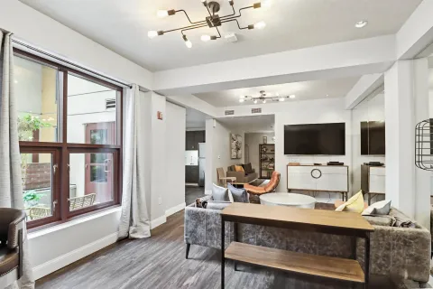 a living room with furniture a flat screen tv and a large window